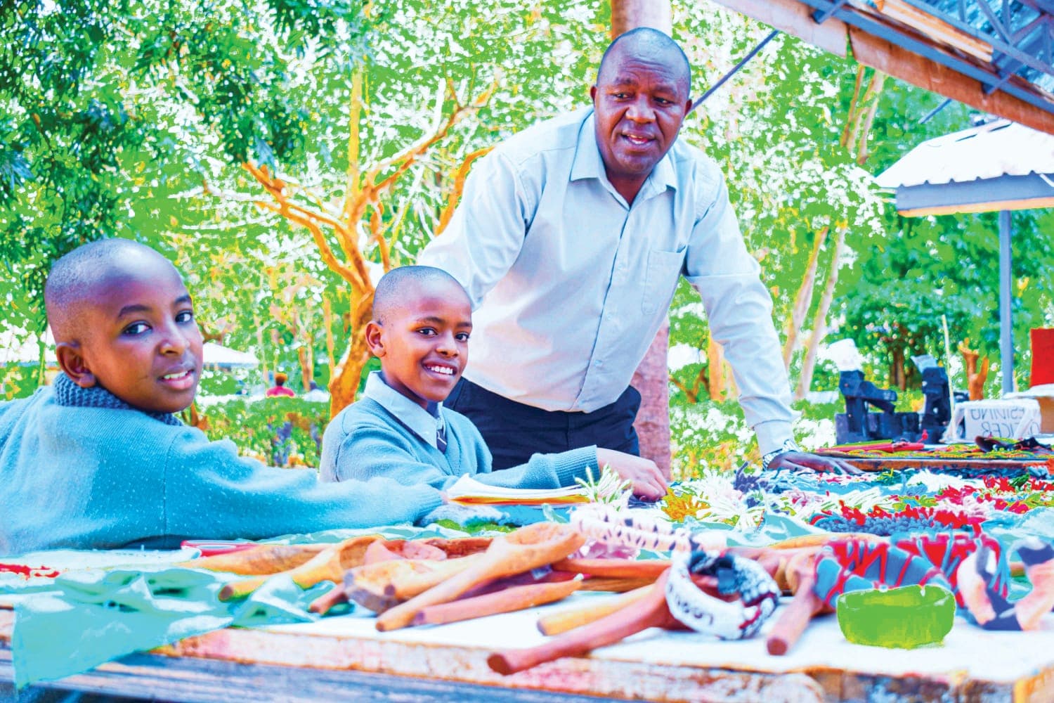 Primary school pupils and their teacher displaying colourful craftwork outdoors
